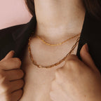 Model wearing a gold filled paperclip chain necklace layered with a delicate gold chain.