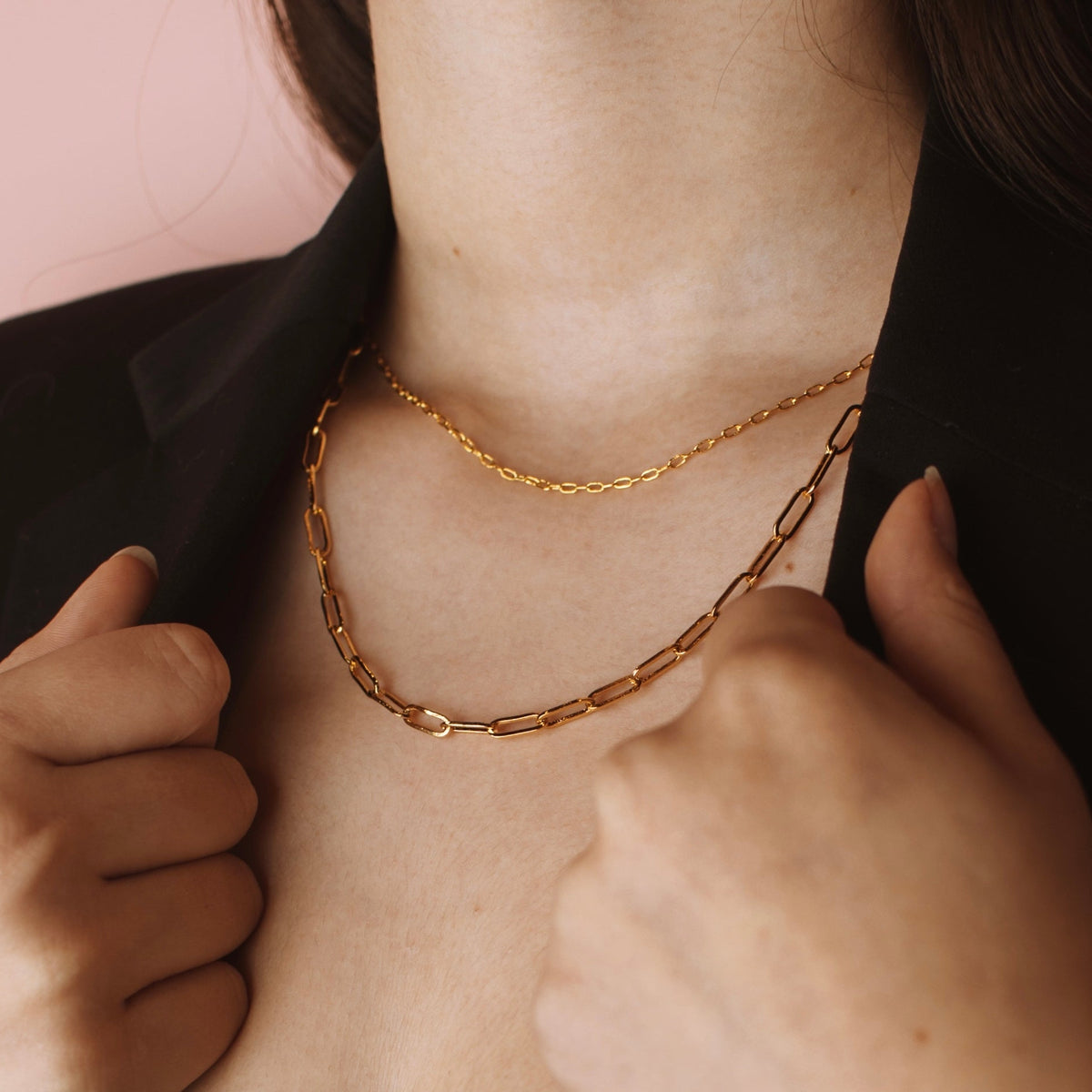 Model wearing a gold filled paperclip chain necklace layered with a delicate gold chain.