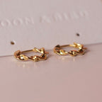 Pair of Wave huggie hoops in 18K gold vermeil with a twisted design on a Moon & Bird card.
