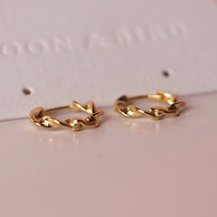 Pair of Wave huggie hoops in 18K gold vermeil with a twisted design on a Moon & Bird card.