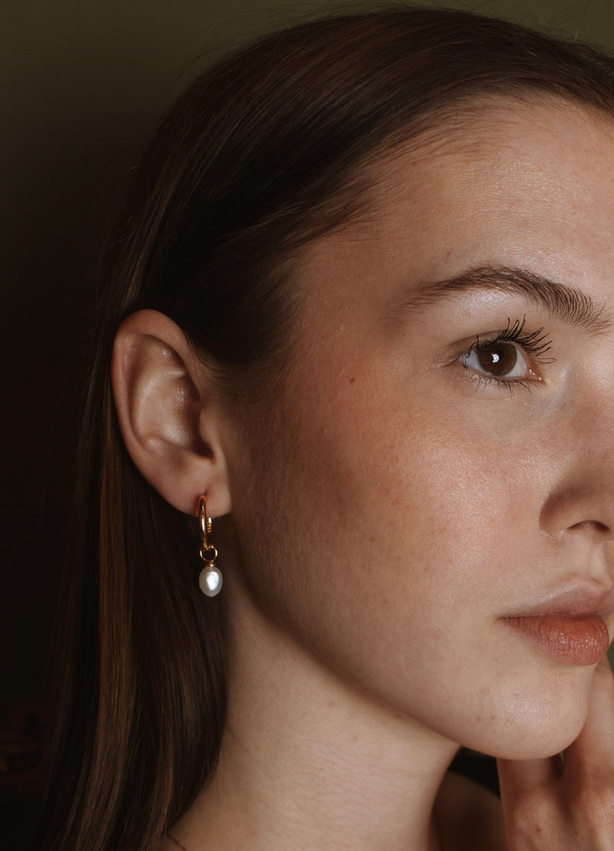 18K gold vermeil pearl drop hoop on a model's ear, a freshwater pearl hanging from the hoop.