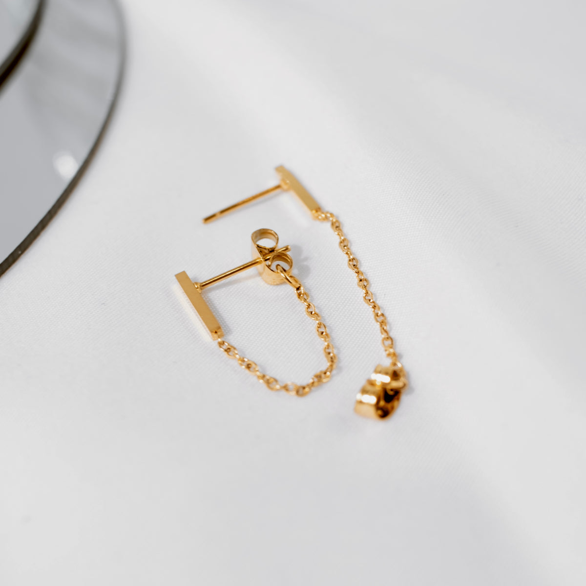 18K gold vermeil bar chain-link stud earring on a white surface, the chain looping from the bar to the backing.