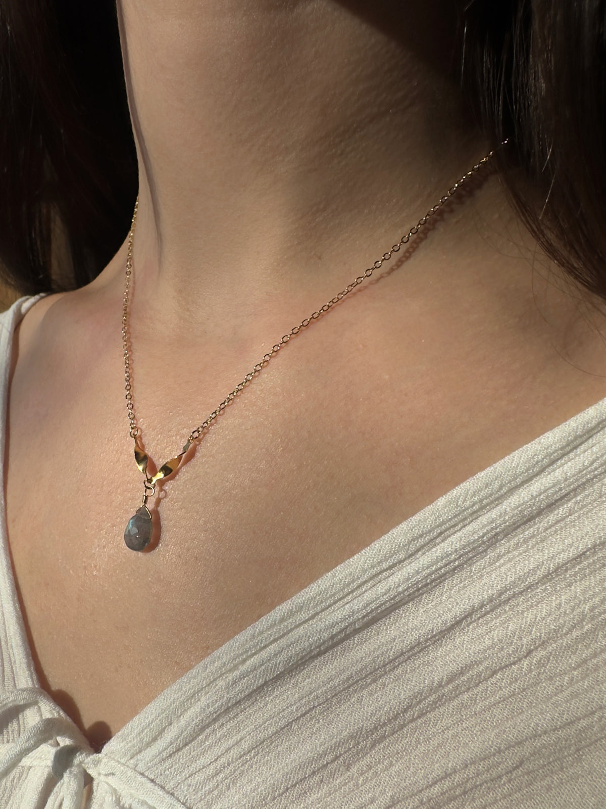 Gold filled labradorite drop necklace on a model, a labradorite teardrop on a fine chain.