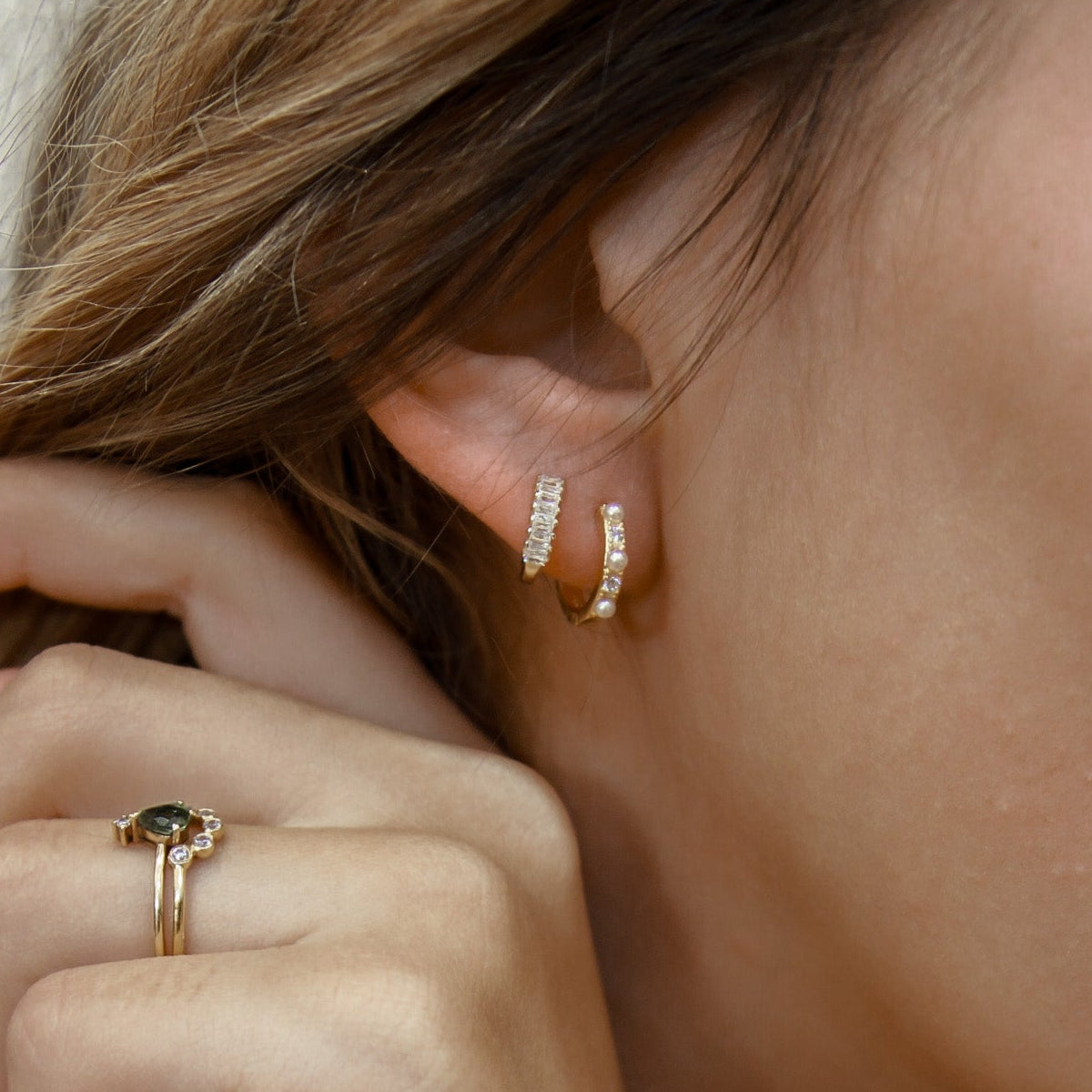 8mm huggie hoop earrings in 18K gold vermeil and 925 sterling silver with baguette cubic zirconia detail, hypoallergenic tarnish-resistant small snap closure hoops styled in ear stack.
