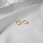 Pair of Tiny Oval Hoops in 18K gold vermeil on white silk.
