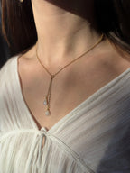 Gold filled rainbow moonstone lariat necklace on a model in sunlight.