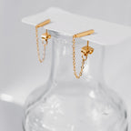 Pair of 18K gold vermeil bar chain-link stud earrings hooked over the rim of a clear glass vase.