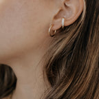 Gold plated stainless steel classic hoop on a model's ear.