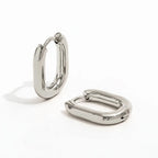 Pair of silver-tone stainless steel oval hoops on a white background.