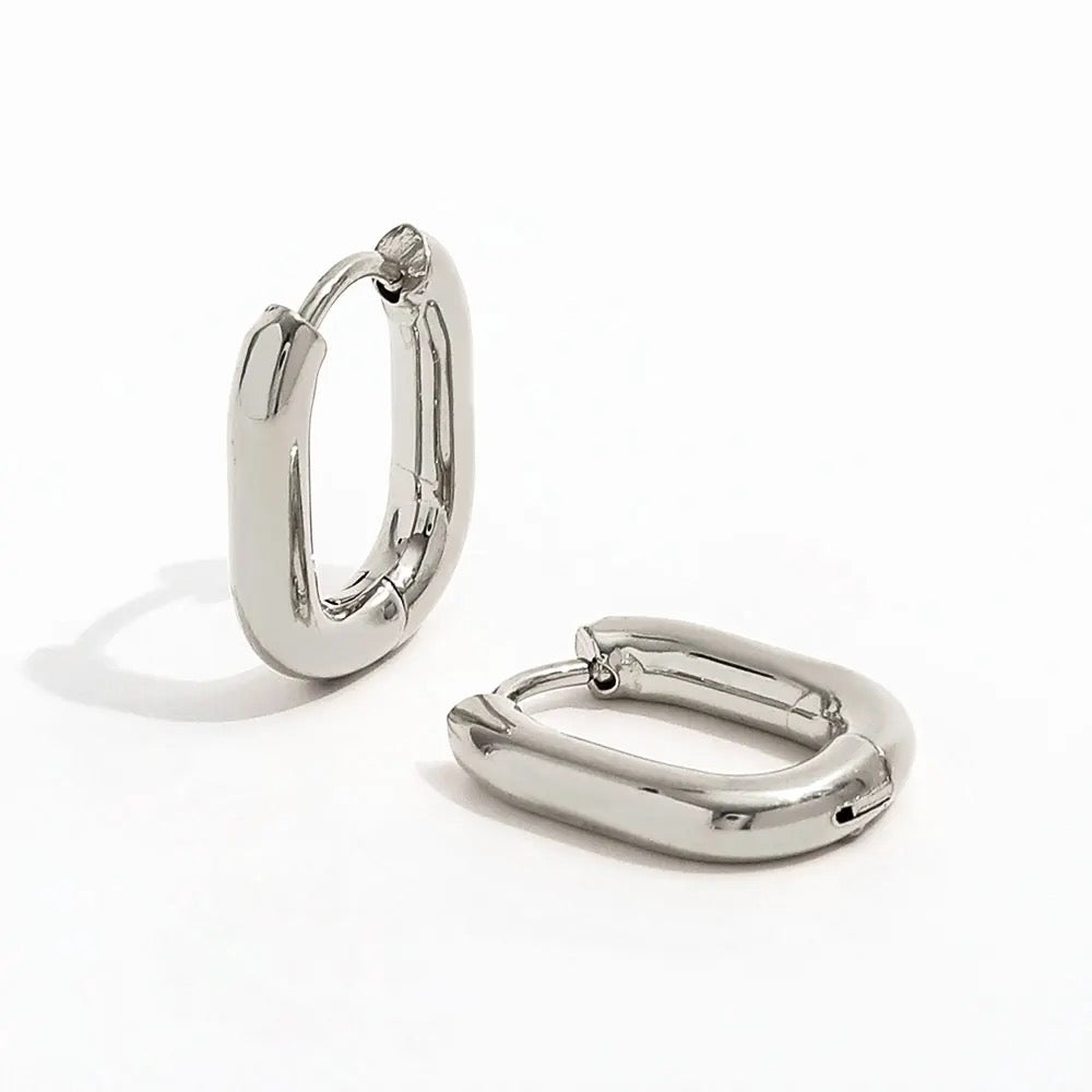 Pair of silver-tone stainless steel oval hoops on a white background.
