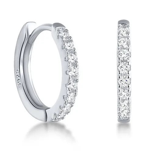 Pair of Tink huggie hoops in sterling silver set with cubic zirconia, front and side view.