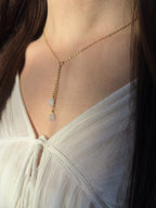 Gold filled rainbow moonstone lariat on a model, two moonstone teardrops on a Y-drop.