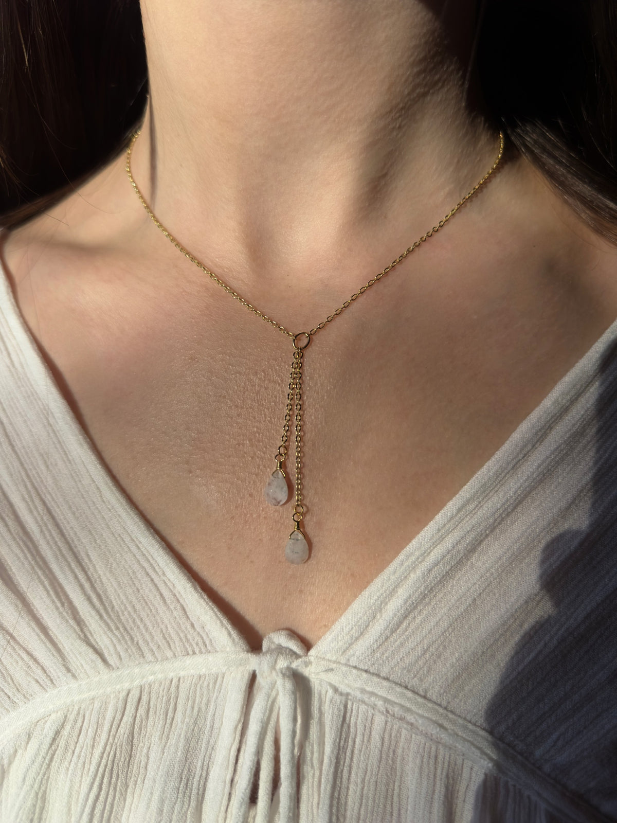 Gold filled rainbow moonstone lariat necklace on a model.