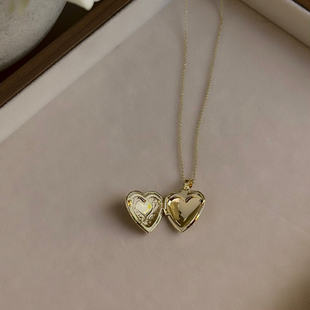 Large Heart locket open on a linen tray, showing both heart-shaped photo windows.