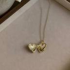 Large Heart locket open on a linen tray, showing both heart-shaped photo windows.