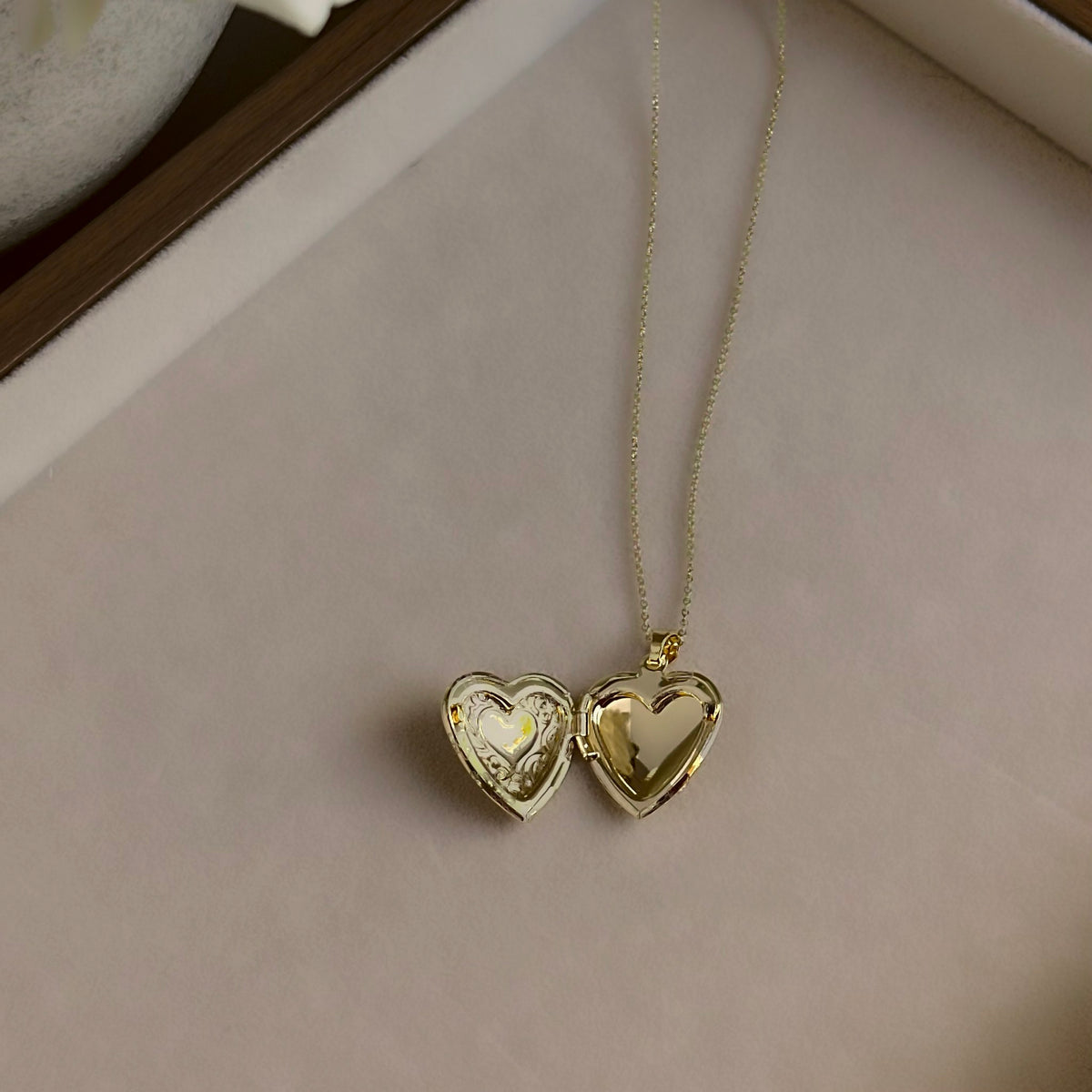 Large Heart locket open on a linen tray, showing both heart-shaped photo windows.