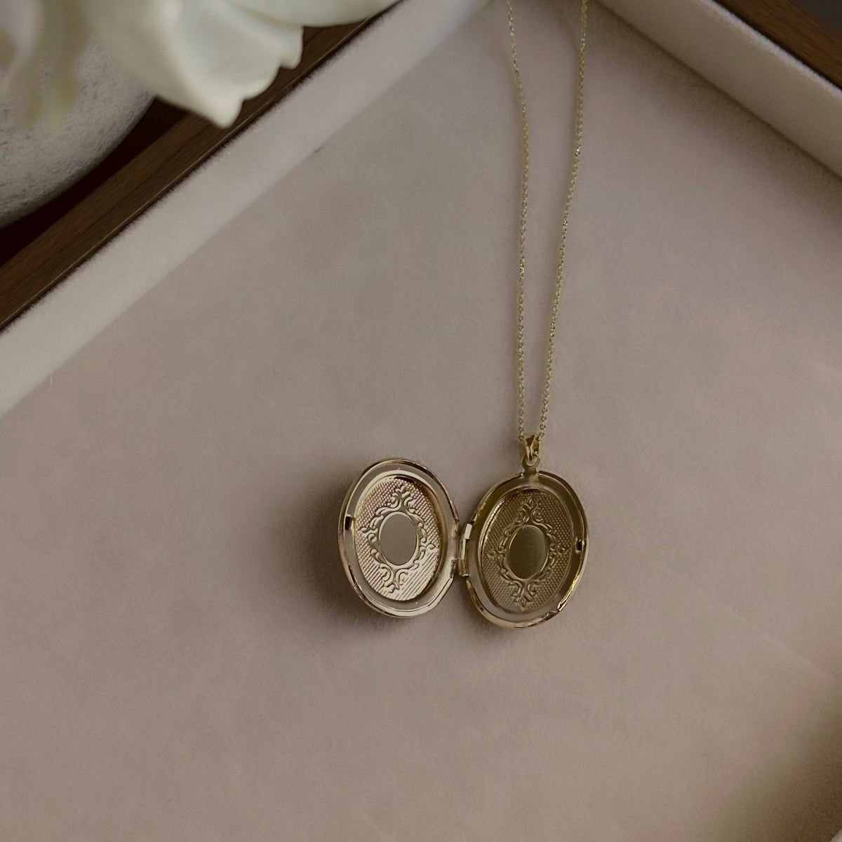 Large Oval locket open on a linen tray, showing both photo windows.