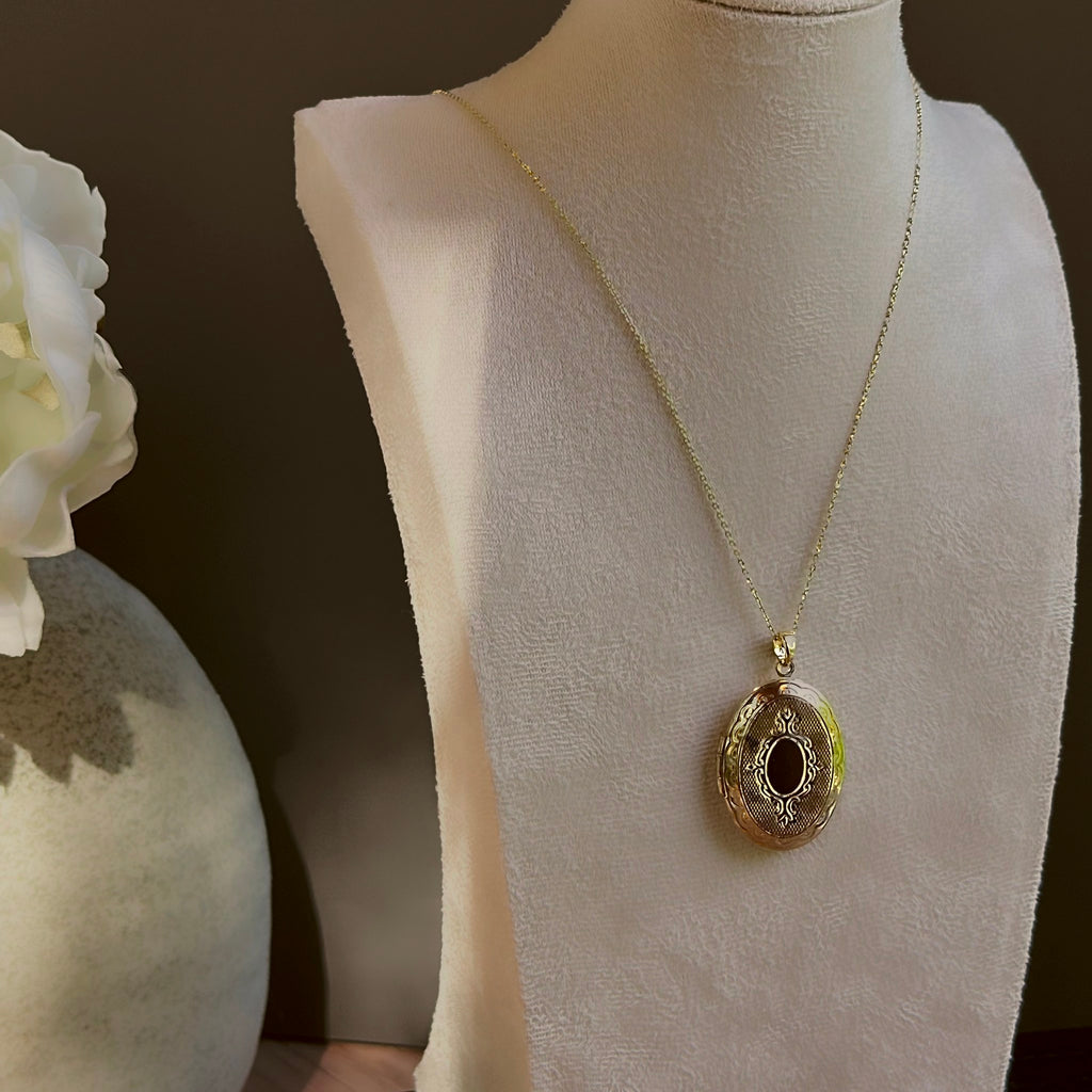 Large Oval locket on a satellite chain, shown on an ivory bust beside a white vase.
