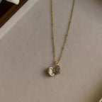 Small Ornate Oval locket open on a linen tray, showing both photo windows.