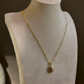 Small Ornate Oval locket on a fine satellite chain, on an ivory bust.