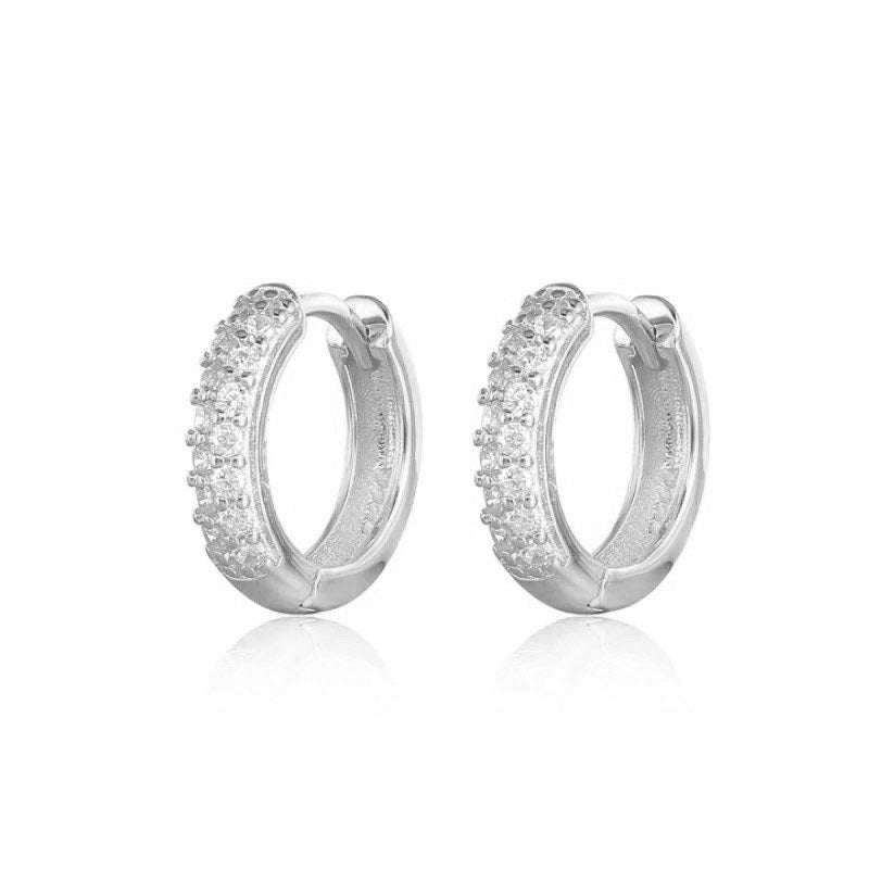 Pair of Sage huggie hoops in sterling silver set with cubic zirconia.