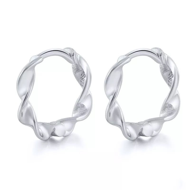 Pair of Wave huggie hoops in sterling silver with a twisted design.