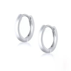 Pair of sterling silver classic huggie hoops on a white background.